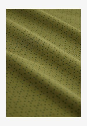 Tissu vert avec une surface texturée présentant un motif fin de petits points vert foncé répartis uniformément.