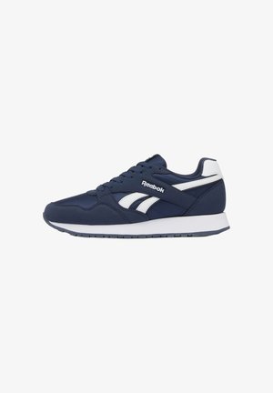 Zapatilla Reebok azul marino y blanca con diseño de cordones, suela acolchada y logo en el lateral, mostrada desde el perfil derecho.