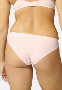 Lichtroze bikini onderkant in een zachte, rekbare stof. Heeft een gematigde dekking aan de achterkant en een naadloos ontwerp voor comfort.