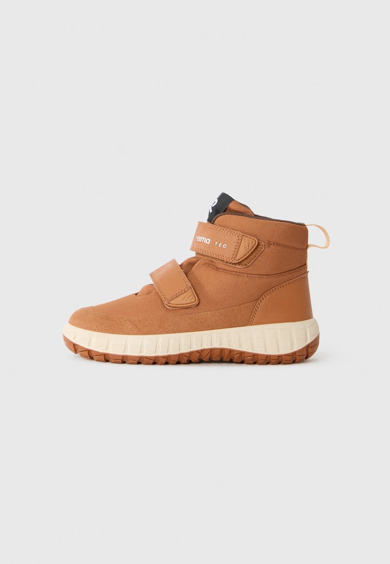 Chaussures brunes mi-hautes avec deux bandes Velcro, tige en tissu texturé, semelle en caoutchouc et semelle intermédiaire beige clair. Talon renforcé pour un enfilage facile.