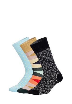 Drei Paar Socken: hellblau mit weißen Punkten, beige mit pinkem geometrischem Design und schwarz mit einem sechseckigen Muster.