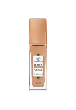 Flacon en verre du fond de teint La Provençale Le Teint en teinte 35 Sable avec un liquide beige et un bouchon bronze métallique.