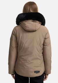 Lichtbruine pufferjas met een zwart gevoerd bontkap, voorzien van een gladde textuur en een label aan de achterkant. Ontworpen voor warmte en comfort.