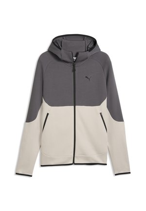 Hættejakke med lynlås med mørkegrå øverste og lysebeige nederste sektioner, lange ærmer, frontlommer med lynlås og et lille Puma-logo på brystet.