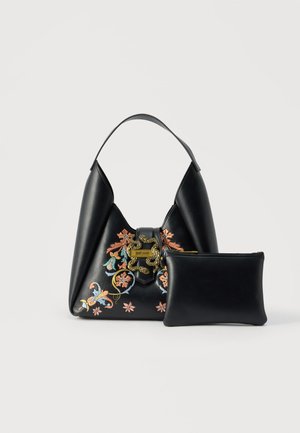 Bolso de cuero negro con bordado floral colorido y cierre de serpiente dorado, acompañado de una funda de cuero negra lisa.