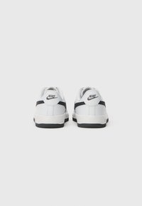 Bijele Nike tenisice s crnim swoosh logom na stražnjoj strani, prikazane sa stražnje strane na jednostavnoj bijeloj pozadini.