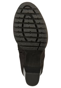 Suela de calzado negra con una superficie de goma texturizada, que presenta una banda de rodadura con patrón para el agarre y un tacón ligeramente elevado.