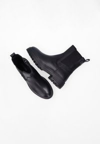 Zwarte leren laarzen met een gestructureerd oppervlak; de ene Chelsea-stijl met elastische zijkant, de andere een gladde instapstijl. Zichtbare rubberen zolen.