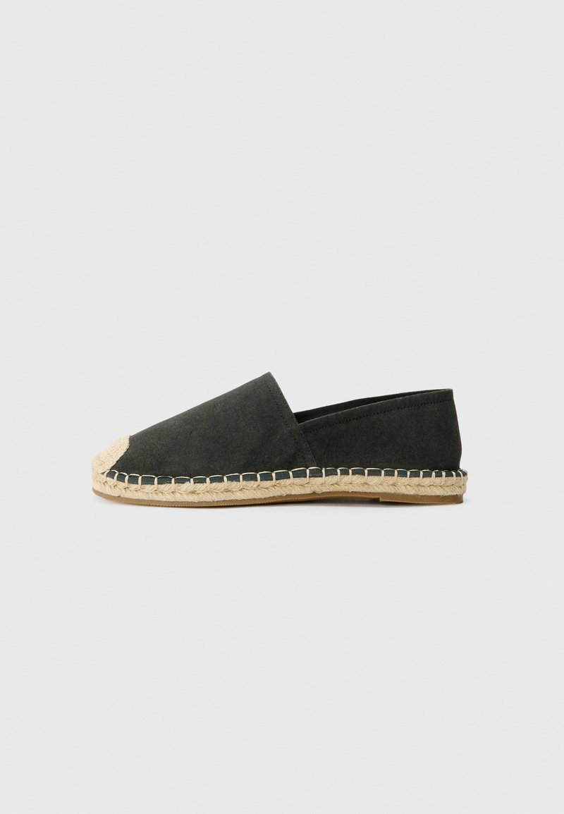 Zelené semišové espadrilky s juty lanovým podošvom, mandľovým priehlavkom a prešitým detailom pozdĺž horného okraja. Jednoduchý, nízkoprofilový dizajn.