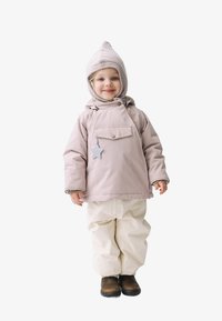 Lichtroze, waterdichte jas met een voorzak en sterlabel; witte waterdichte broek; bruine laarzen; geribde muts met puntige bovenkant.