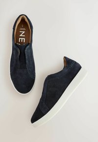 Zapatillas azul marino tipo slip-on con acabado de ante, que presentan una suela de goma blanca y paneles laterales elásticos para una fácil colocación.