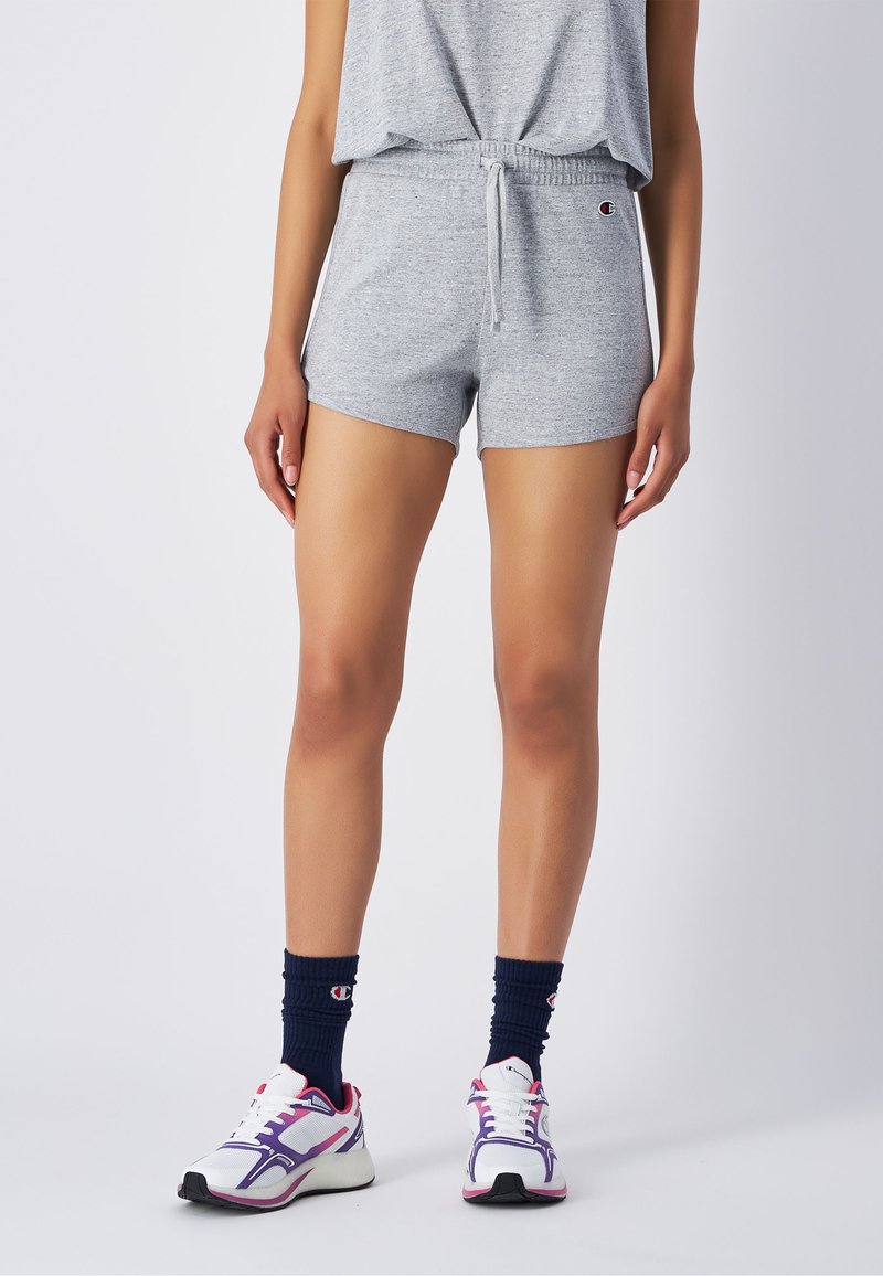 Graue Baumwollmischung-Shorts mit einem elastischen Taillenbund und einer Kordel. Kombiniert mit weißen Sportschuhen und marineblauen Kniestrümpfen mit Logo.