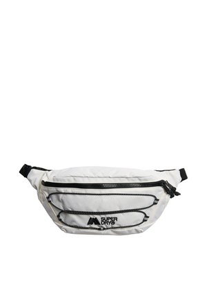 Riñonera blanca de la marca Superdry con cremallera negra, correa ajustable y cordones negros decorativos en el bolsillo frontal.