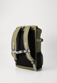Zaino verde oliva con pannello posteriore in rete, spallacci imbottiti, accenti grigi e maniglia superiore; presenta un design minimalista e materiale durevole.