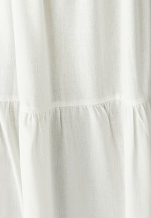 Balts lina audums ar nedaudz strukturētu virsmu, ar ievilkumiem apakšmalā, lai piešķirtu papildu detaļas.