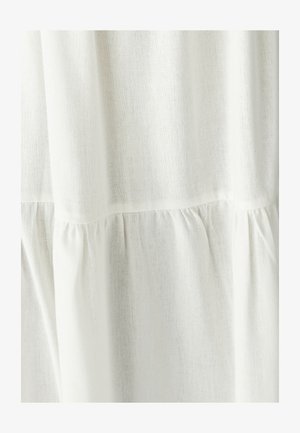 Balts lina audums ar nedaudz strukturētu virsmu, ar ievilkumiem apakšmalā, lai piešķirtu papildu detaļas.