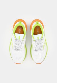 Baskets blanches de sport avec une tige en mesh respirant, des accents vert lime et orange, des lacets gris et une semelle rembourrée pour le confort.