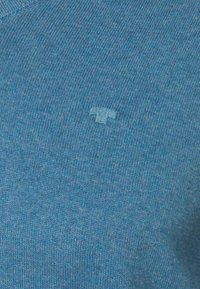 Hellblaues Strickpullover mit einem kleinen, dezenten gestickten Logo in passender Farbe auf der Vorderseite. Weiche Textur mit glatter Oberfläche.