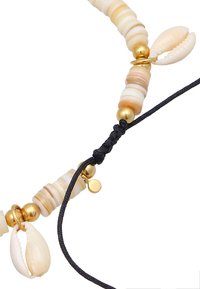 Collana con perle di conchiglia beige e bianche, dettagli dorati e una corda nera regolabile con un nodo e un piccolo charm dorato.