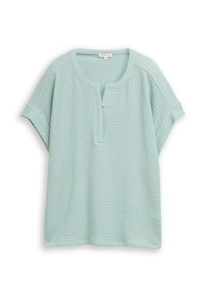 Lichtblauw textuur katoenen blouse met korte mouwen, ronde halslijn, één met stof beklede knoop aan de voorkant en een losse, ontspannen pasvorm.