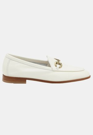 Mocasines de cuero blanco con punta afilada, que presentan un acento de hardware en tono dorado en la parte superior y un tacón marrón apilado. Textura suave.
