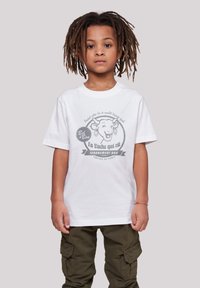 Weißes Baumwoll-T-Shirt mit einem grauen Cartoon-Kuh-Design und französischem Text, runder Logo und kurzen Ärmeln. Dazu getragen mit olivgrünen Cargo-Shorts.