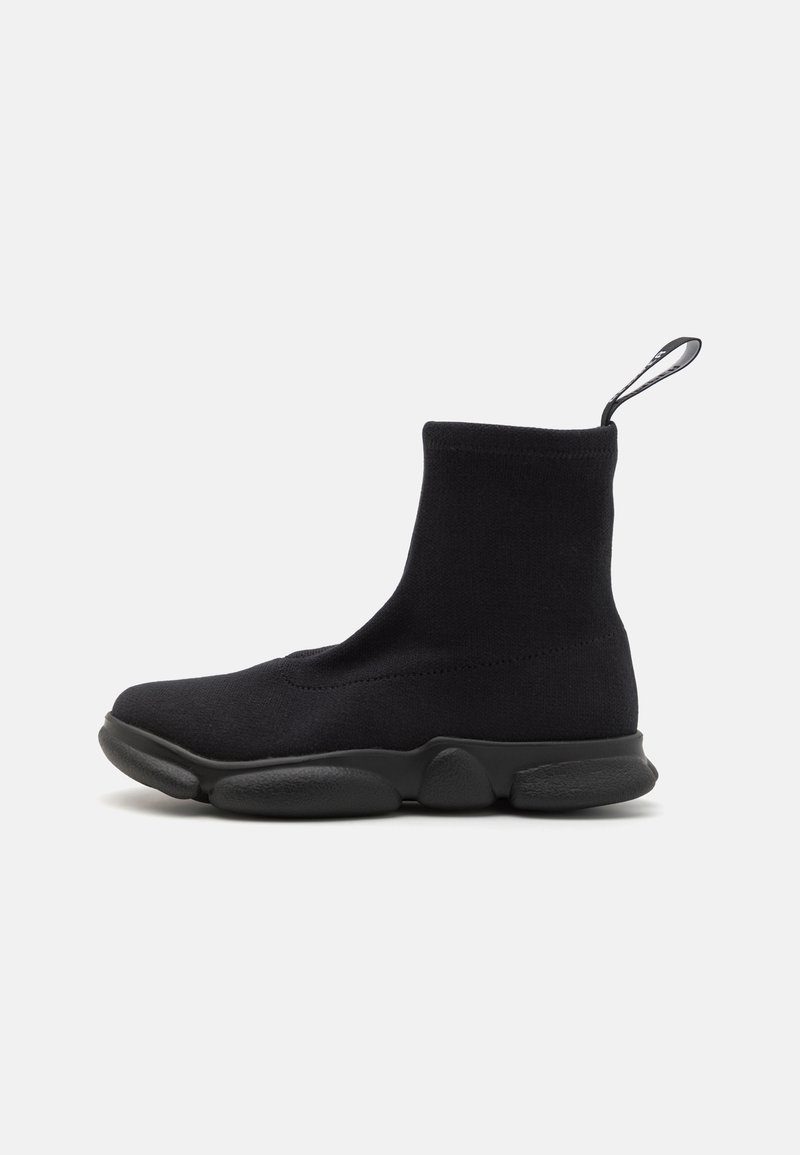 Botine negre, stil ciorap, cu o parte superioară din textil neted, talpă groasă din cauciuc și o bucată de material la spate pentru a fi ușor de încălțat.