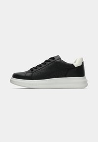 Baskets en cuir noir avec des détails texturés, bout rond, design à lacets, et une semelle en caoutchouc blanc arborant un logo subtil.