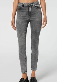 Szare skinny jeans z wypłowiałym wykończeniem, wysoki stan, kieszenie z przodu i dopasowany krój. Wyróżniają się kontrastowym przeszyciem i gładką teksturą.