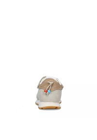 Sneaker con tomaia in suede beige e bianco, forma arrotondata, design senza lacci e un toggle blu e arancione per la regolazione. Suola in gomma.