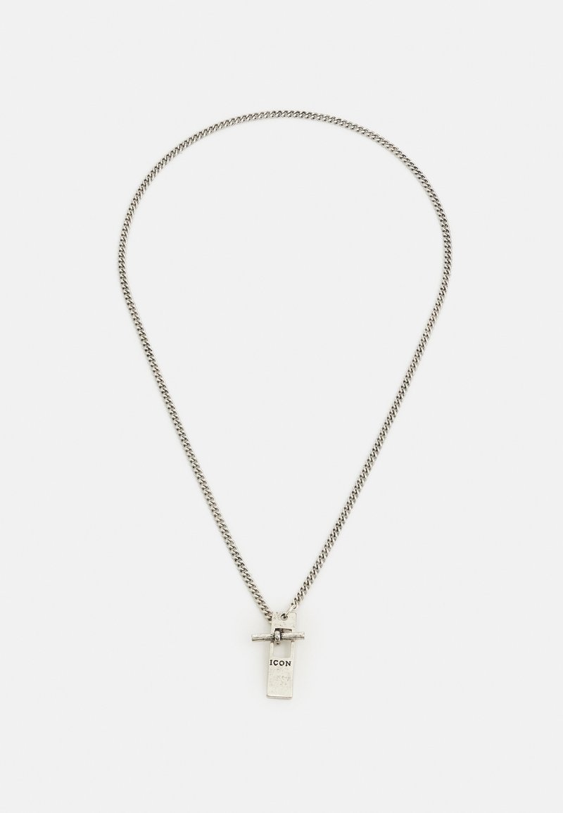 Colar de corrente prateada com um pendente retangular que apresenta a palavra "ICON." O pendente inclui um detalhe em forma de cruz na parte superior.