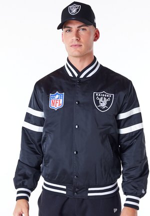 Giacca bomber nera con strisce bianche, loghi NFL e Raiders. Collo, polsini e orlo a coste. Tessuto morbido e lucido con imbottitura trapuntata.
