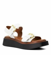 Witte leren platform sandalen met dubbele gespbanden, een bruine houten tussenzool en een zwarte rubberen buitenzool met een gestructureerd profiel.