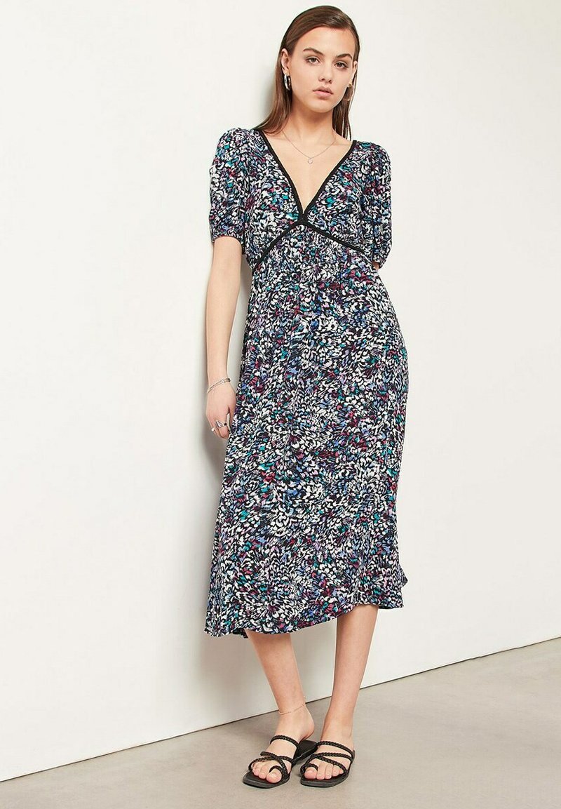 Maxi jurk met bloemenprint in donkerblauw met meerdere kleuren. Beschikt over een diepe V-hals, korte pofmouwen en een relaxed silhouet.