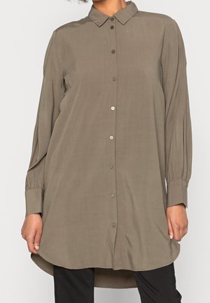 Chemise à manches longues, couleur olive avec un devant boutonné, un col classique et un ourlet arrondi. Présente une légère texture et des manches à poignets.