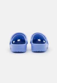 Niebieskie gumowe klapki z otwartym tyłem, wyposażone w teksturowane wkładki i otwory wentylacyjne, zaprojektowane z myślą o komforcie i wentylacji.