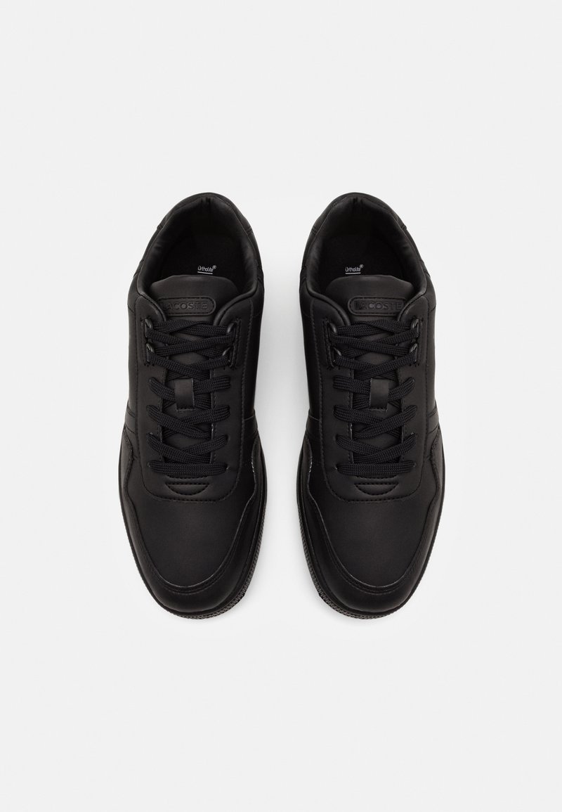 Black sneakers with a smooth leather upper, rounded toe, lace-up design, and textured rubber sole. Features logo detail on the tongue.