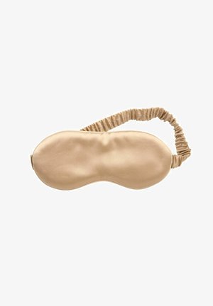 Masque de sommeil en satin beige avec une bande élastique froncée conçue pour couvrir les yeux et bloquer la lumière pour un sommeil réparateur.