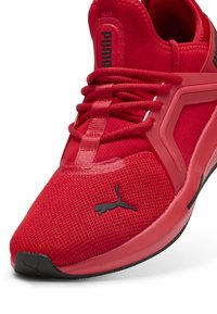 Crvena atletska cipela od mrežastog materijala, sa istaknutim Puma logotipom, ravnim vezicama i strukturiranom gumiranom potplatom za bolje prianjanje.