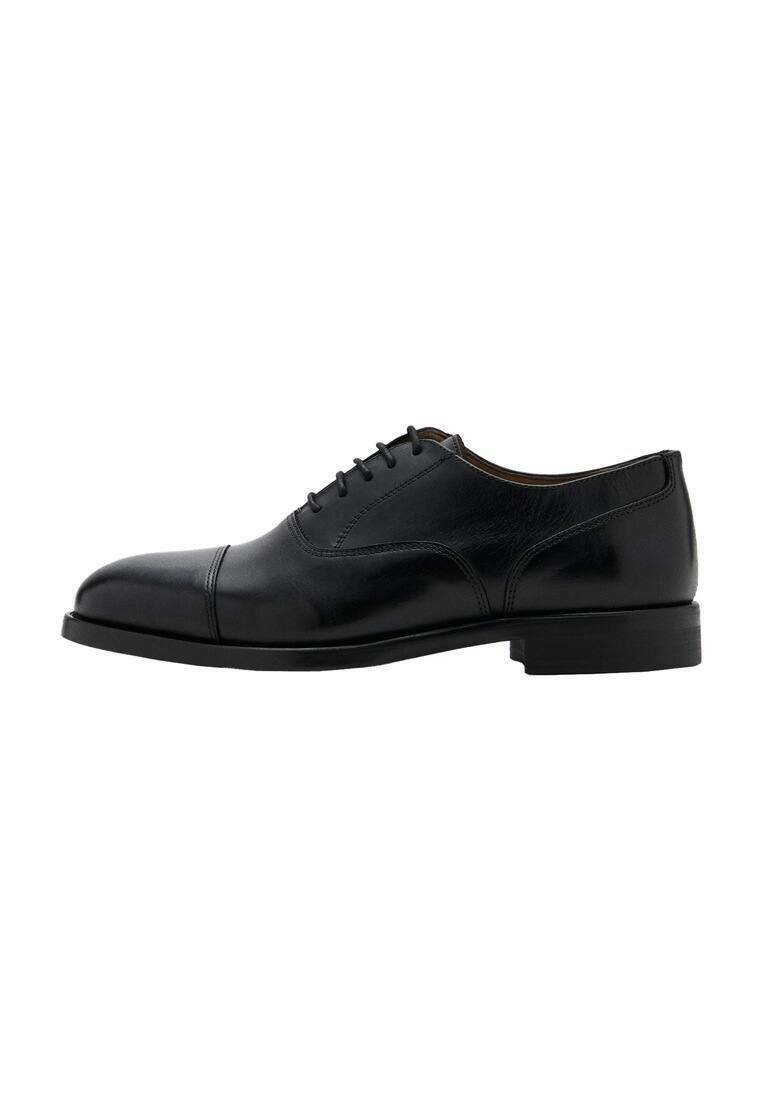 Zapato de vestir de cuero negro con acabado liso, punta redondeada y cinco ojales para cordones. Presenta un tacón bajo y rectangular y un diseño elegante.