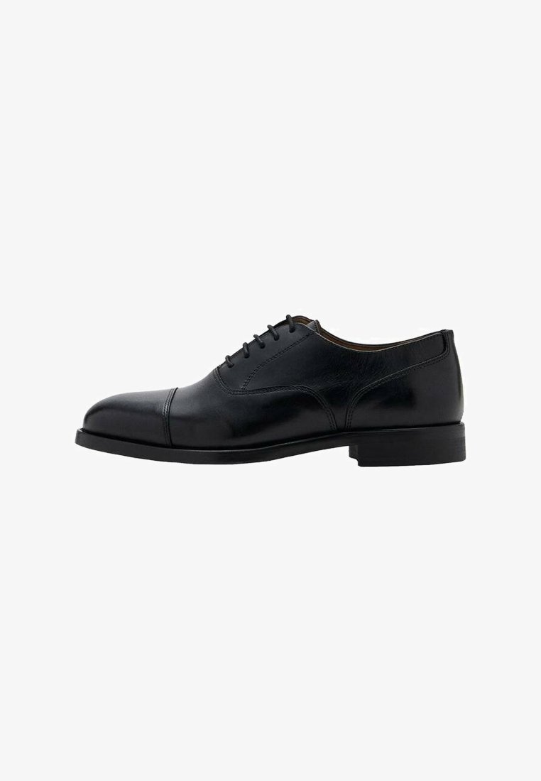 Zapato de vestir de cuero negro con acabado liso, punta redondeada y cinco ojales para cordones. Presenta un tacón bajo y rectangular y un diseño elegante.