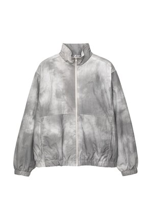 Giacca a vento grigia leggera con motivo tie-dye, colletto alto, chiusura frontale con zip e polsini ed orlo elasticizzati.