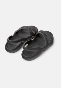 Black rubber sandals with a minimalist design. They feature two flexible straps and a textured footbed for comfort.