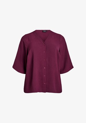 Blusa bordeaux con bottoni, scollatura a V, maniche corte e larghe, e tessuto texturizzato. Presenta cinque bottoni abbinati lungo la parte anteriore.