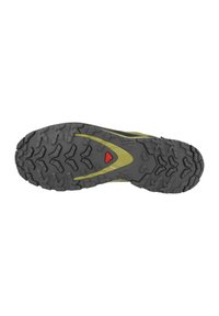 Suola di scarpe da trail running grigia con profondi pattern di battistrada, caratterizzata da un accento giallo e un logo rosso centrale per migliorare la presa e la stabilità.