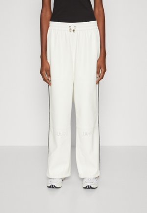 Pantaloni sportivi bianchi, comodi e larghi, con strisce laterali nere, dotati di un vita regolabile con cordino e logo "LIU JO" vicino all'orlo inferiore.