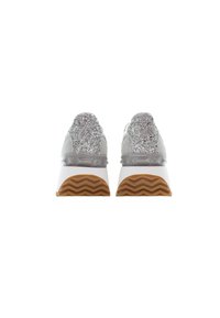 Baskets à talons pailletés argentés avec semelles intermédiaires blanches et semelles en caoutchouc marron à motif zigzag, vues de dos.