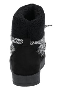 Musta samettinen nilkkabooti, jossa on teksturoitu fleece-vuori, musta-valkoinen kuvioitu nauha ja kumipohja. Takakatsaus esitetty.