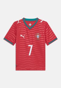 Κόκκινη ποδοσφαιρική φανέλα της Πορτογαλίας με πράσινες λεπτομέρειες, λευκά λογότυπα Puma, κυματιστό μοτίβο, αριθμό 7 και το έμβλημα της εθνικής ομάδας στο στήθος.