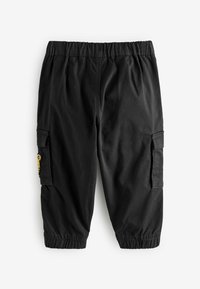 Pantalon noir pour enfants avec ceinture élastique, poches cargo et bas élastiqués, posé à plat sur un fond blanc.